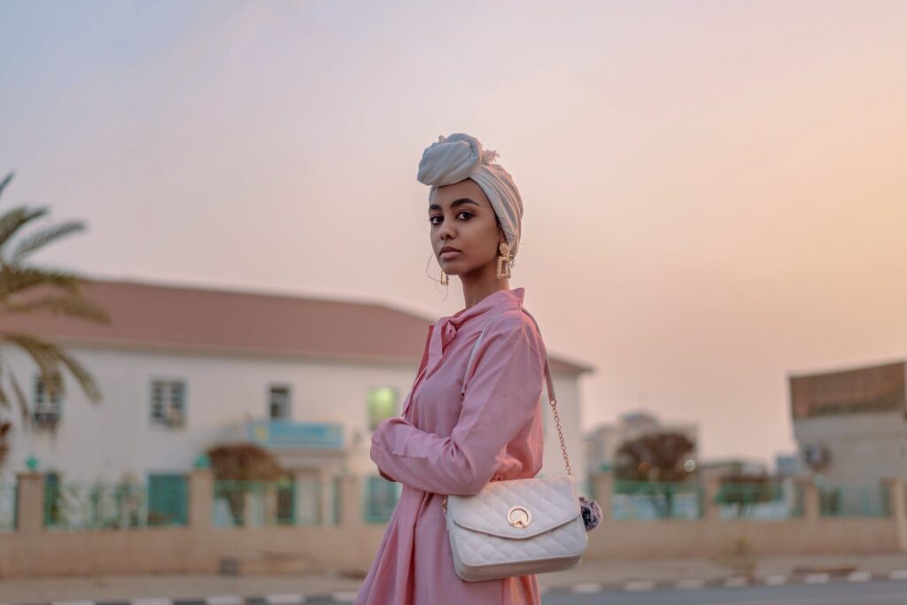 selective focus photograph of woman in pink dress with leather bag